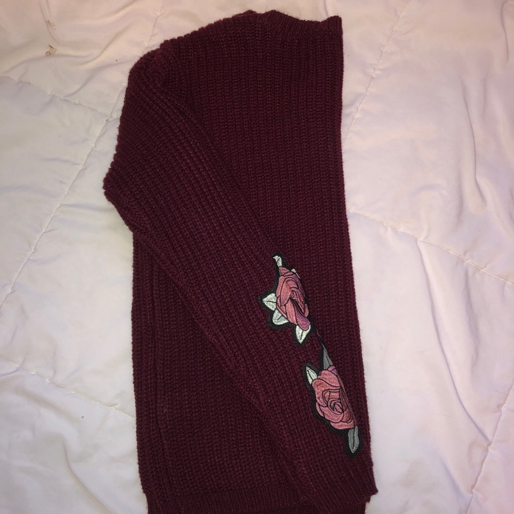 maroon sweater with rose details on the arm
